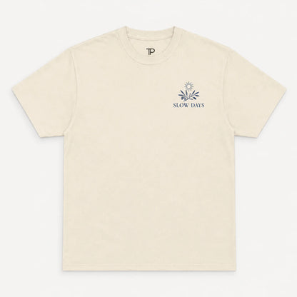 Beige t-shirt with 'Slow Days' logo on a white background