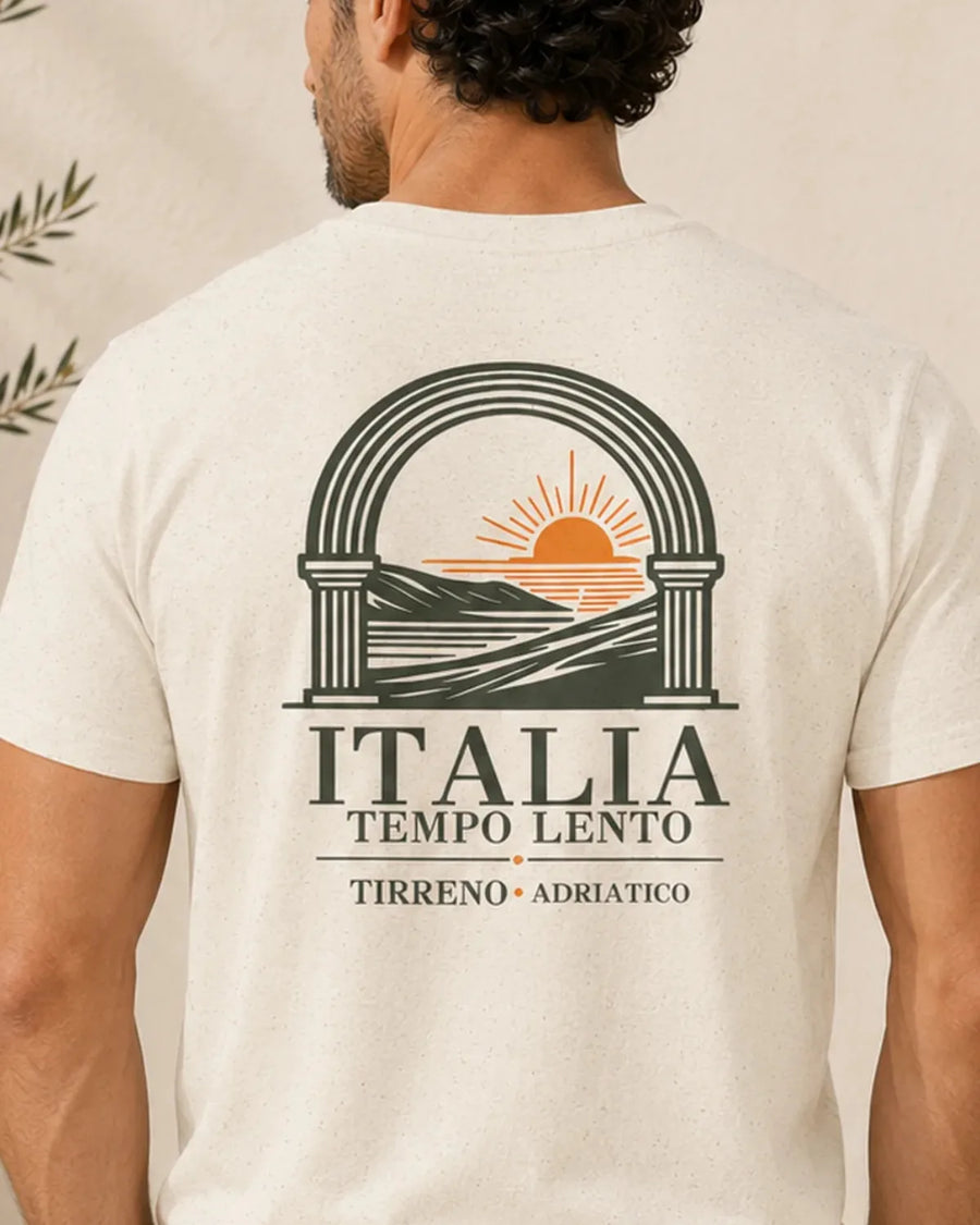 Model wearing the Natural Italia Tempo Lento T-shirt with a small Italian coastal design on the left chest.