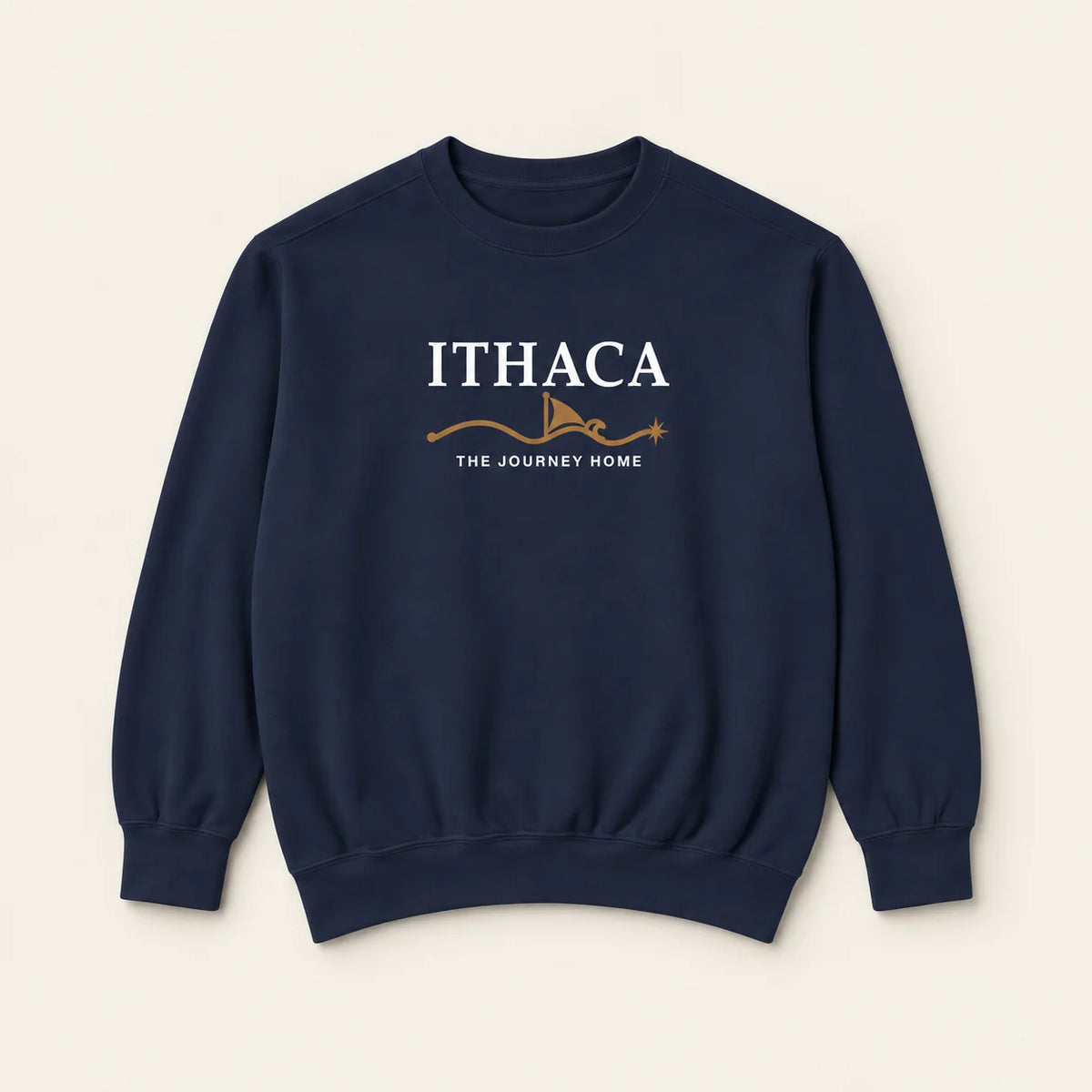 A navy blue crewneck sweatshirt with a graphic on the chest reading 'ITHACA' and 'THE JOURNEY HOME' in white, with a small brown illustration below, displayed on a light beige background.