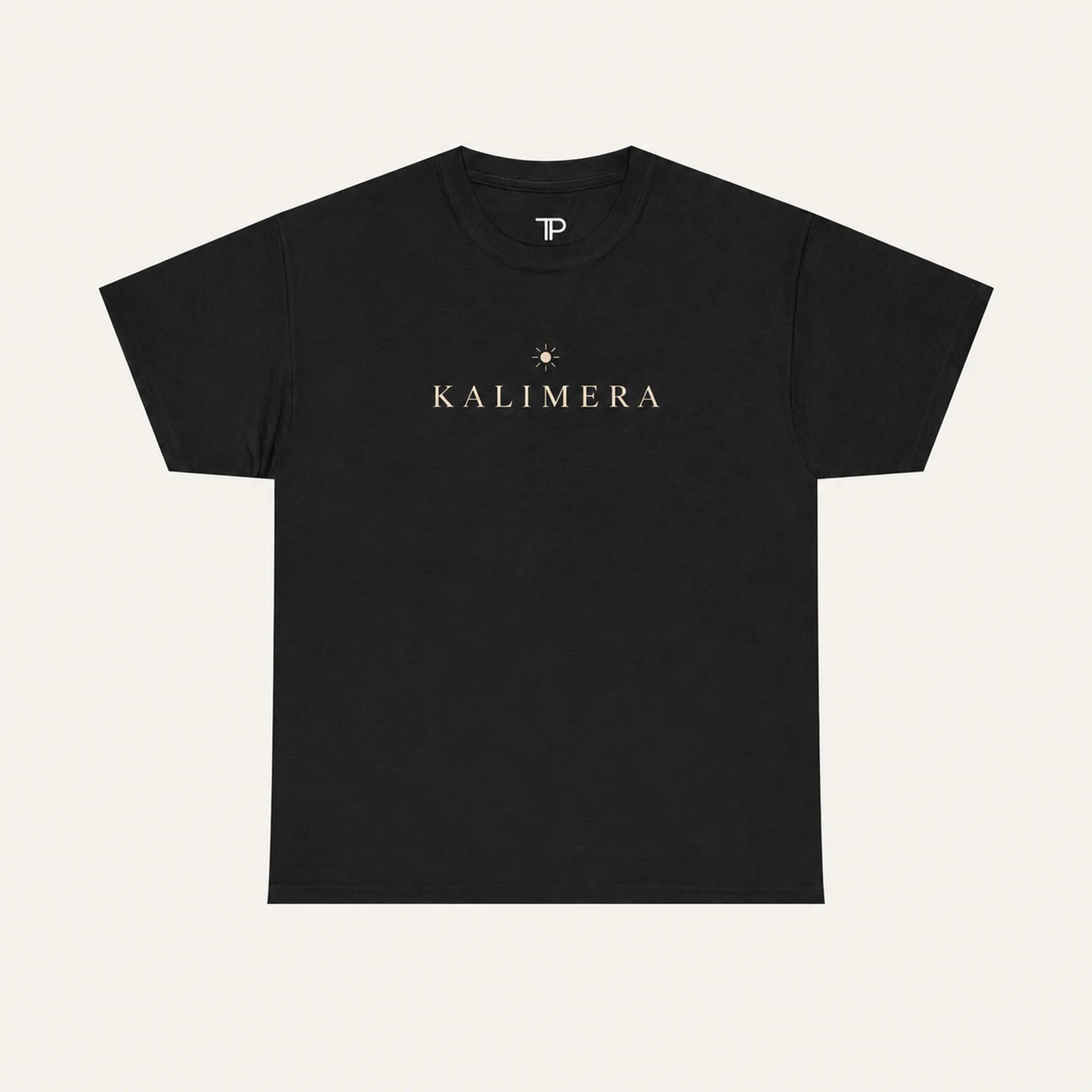 A black short-sleeve crewneck t-shirt with 'KALIMERA' printed in gold across the chest, accompanied by a small gold star graphic, shown against a light cream background.
