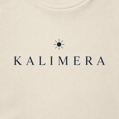 Close-up of a natural-colored crewneck sweatshirt featuring the brand name 'KALIMERA' in navy blue serif lettering with a small sun icon above it.