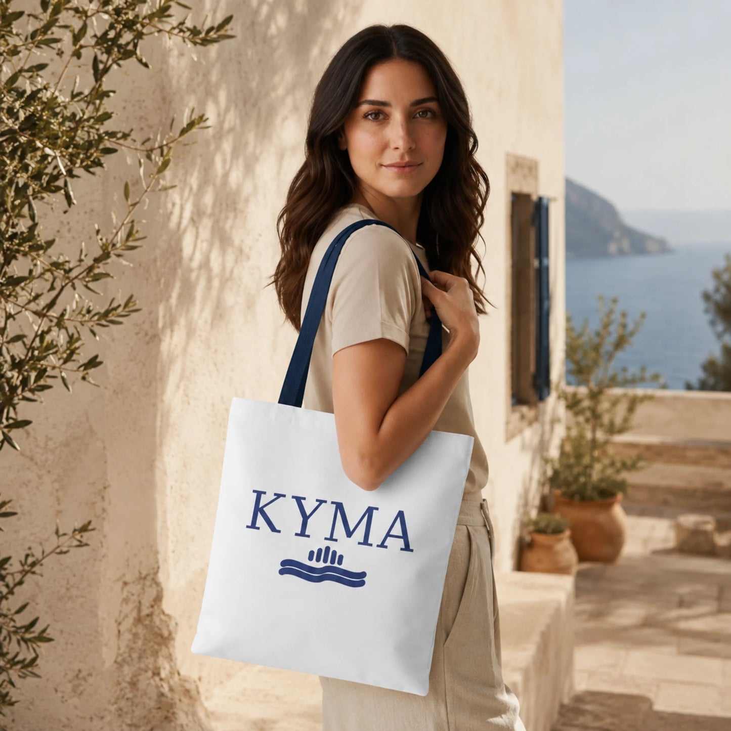 Woman holding a KYMA tote bag with a scenic background