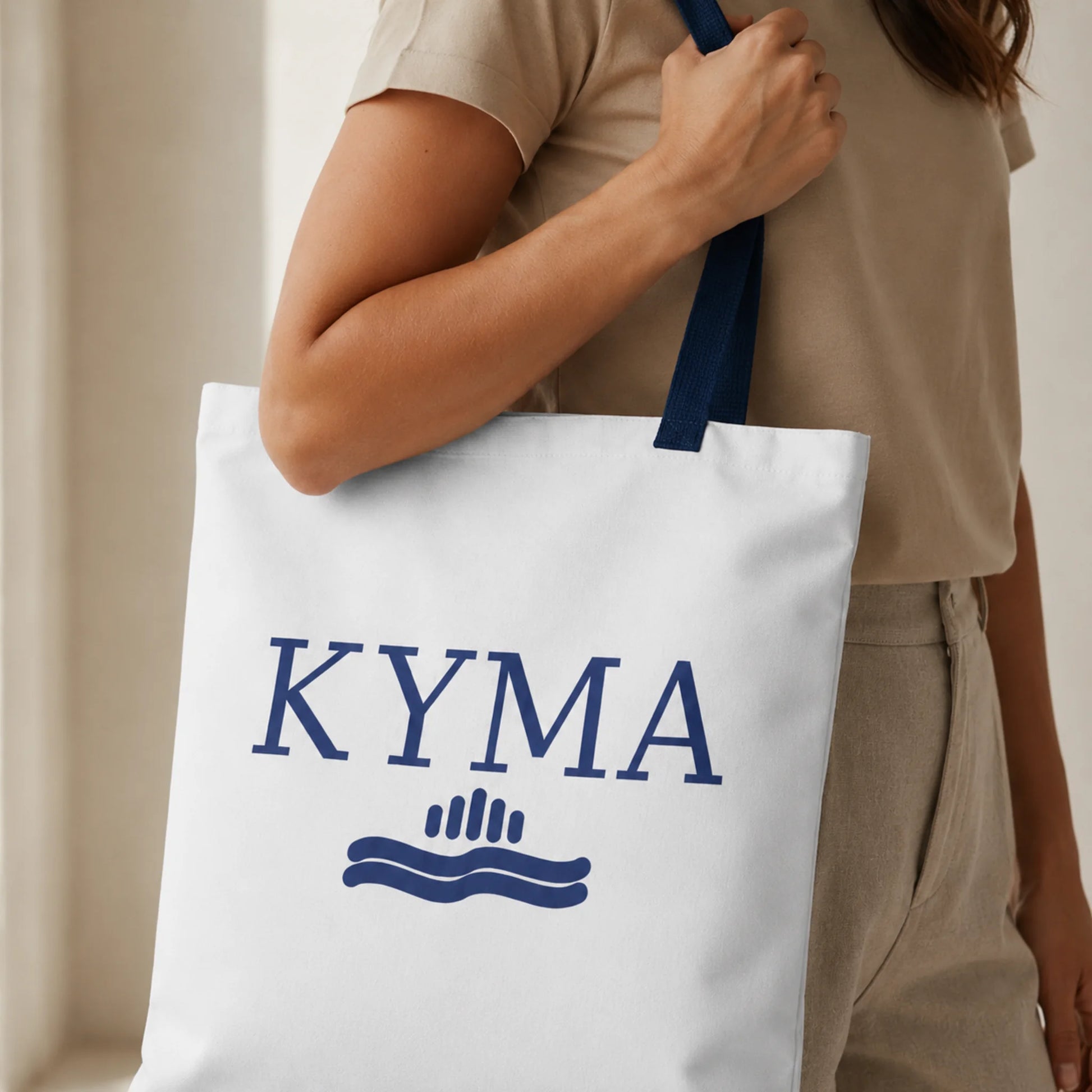 TP HERO: Person holding a white tote bag with 'KYMA' branding.