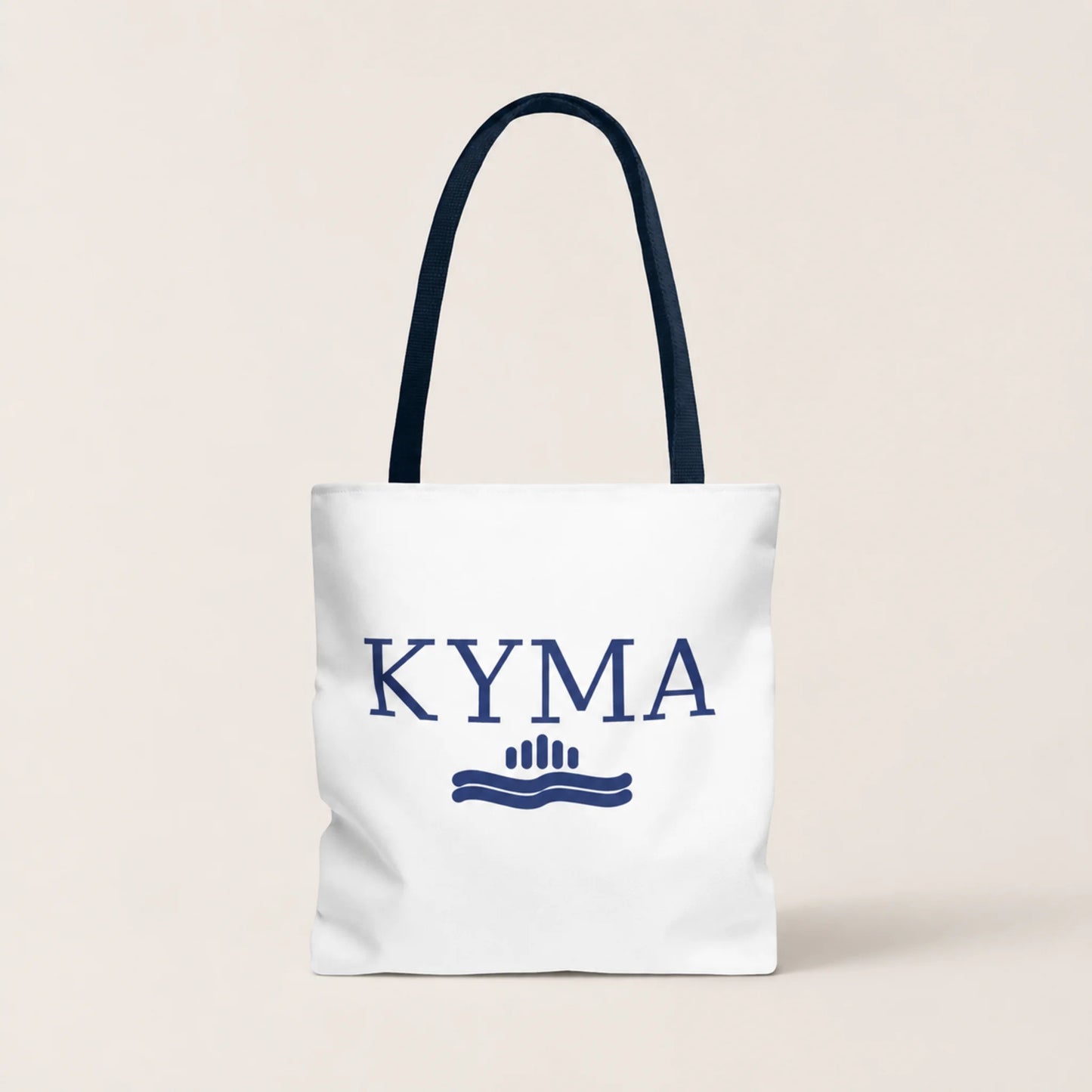 White tote bag with 'KYMA' branding on a beige background