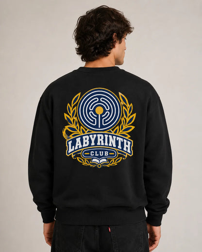 A man viewed from behind wearing a black crewneck sweatshirt with a large graphic on the back. The graphic features a blue and yellow labyrinth design with the text 'LABYRINTH CLUB'.