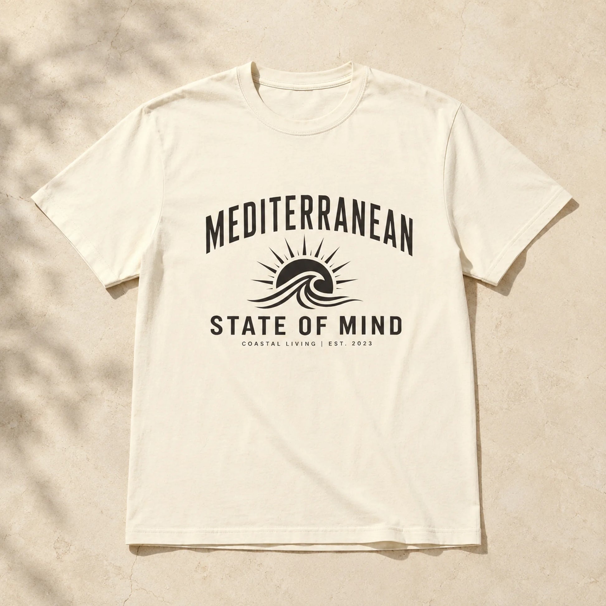 White t-shirt with 'Mediterranean State of Mind' design on a beige background