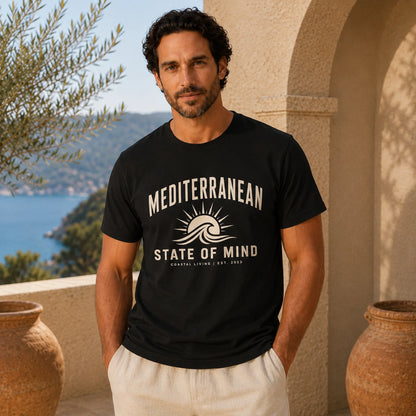 Man wearing a black t-shirt with 'Mediterranean State of Mind' design, standing outdoors with scenic background.