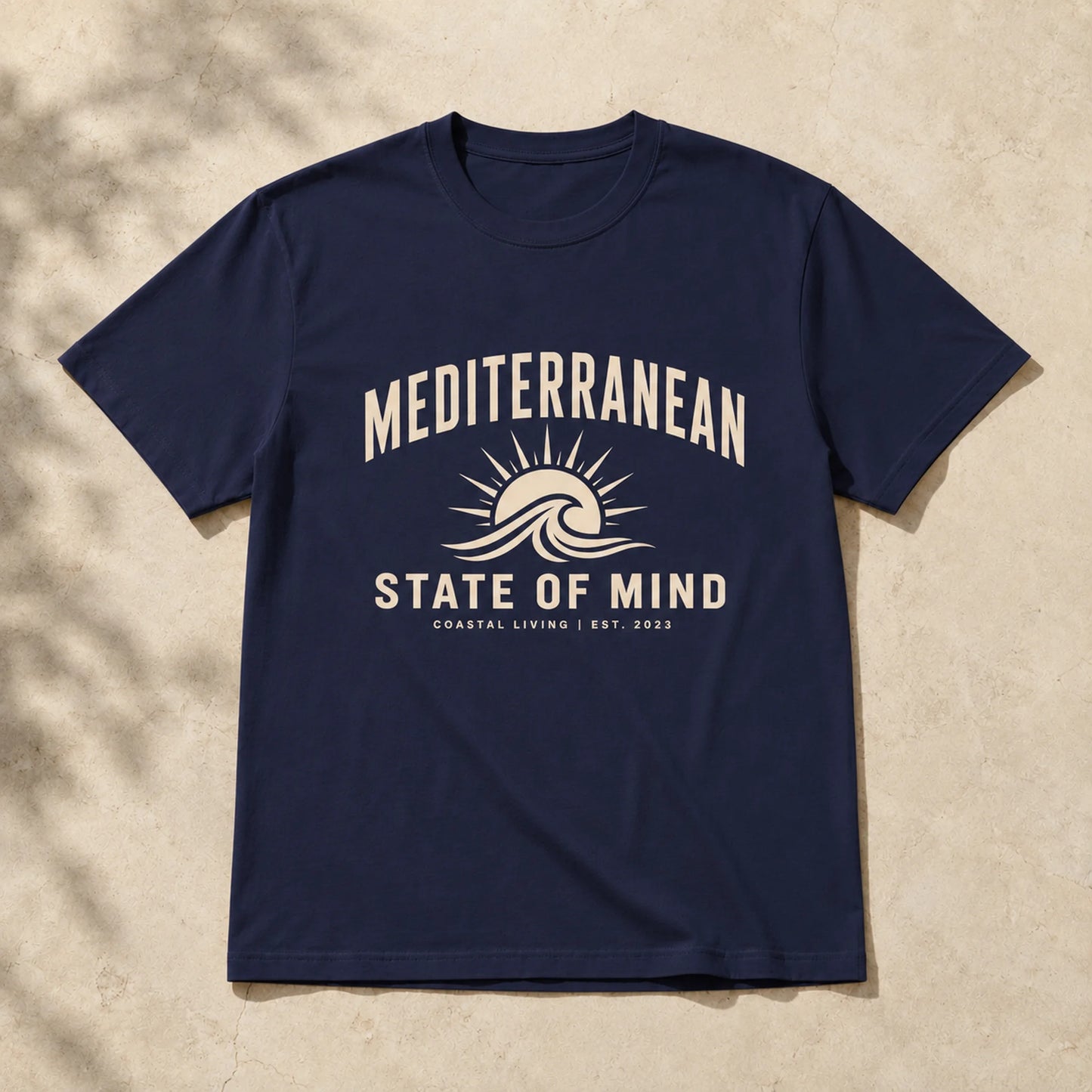 Navy blue t-shirt with 'Mediterranean State of Mind' design on a beige background