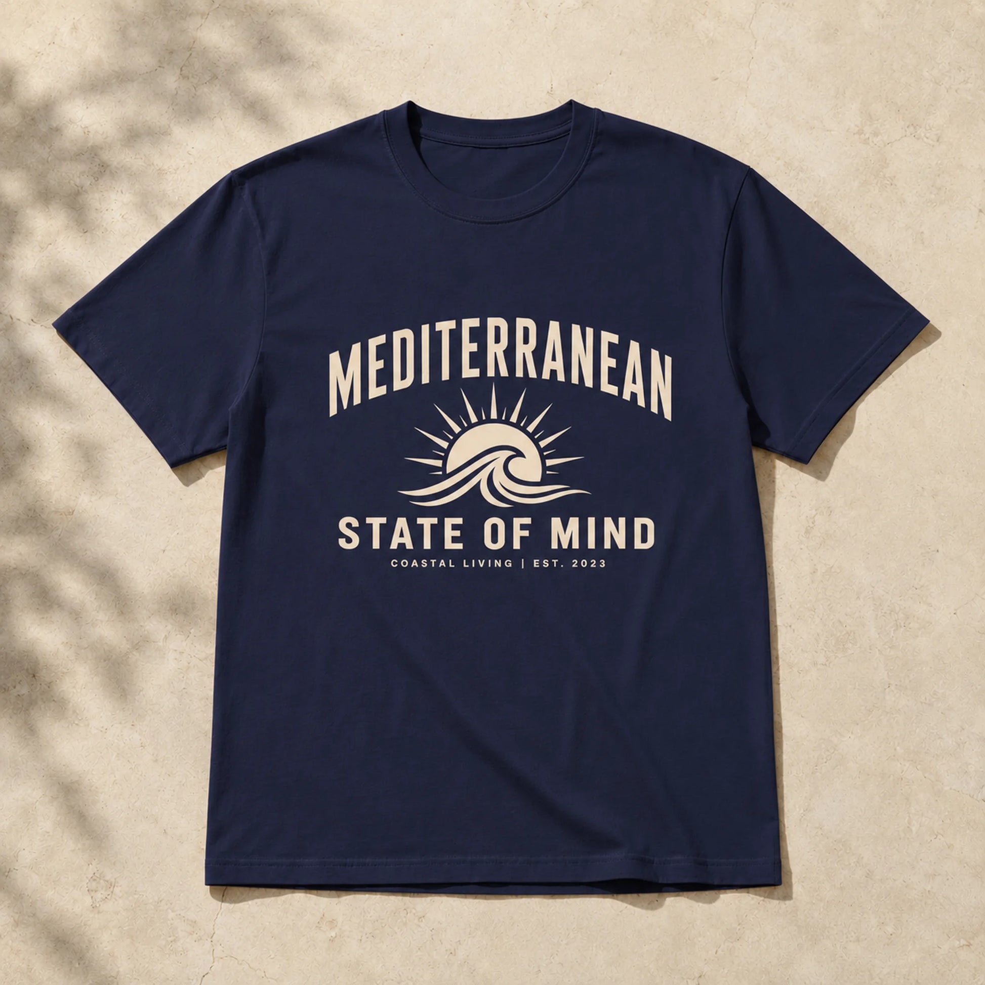 Navy blue t-shirt with 'Mediterranean State of Mind' design on a beige background