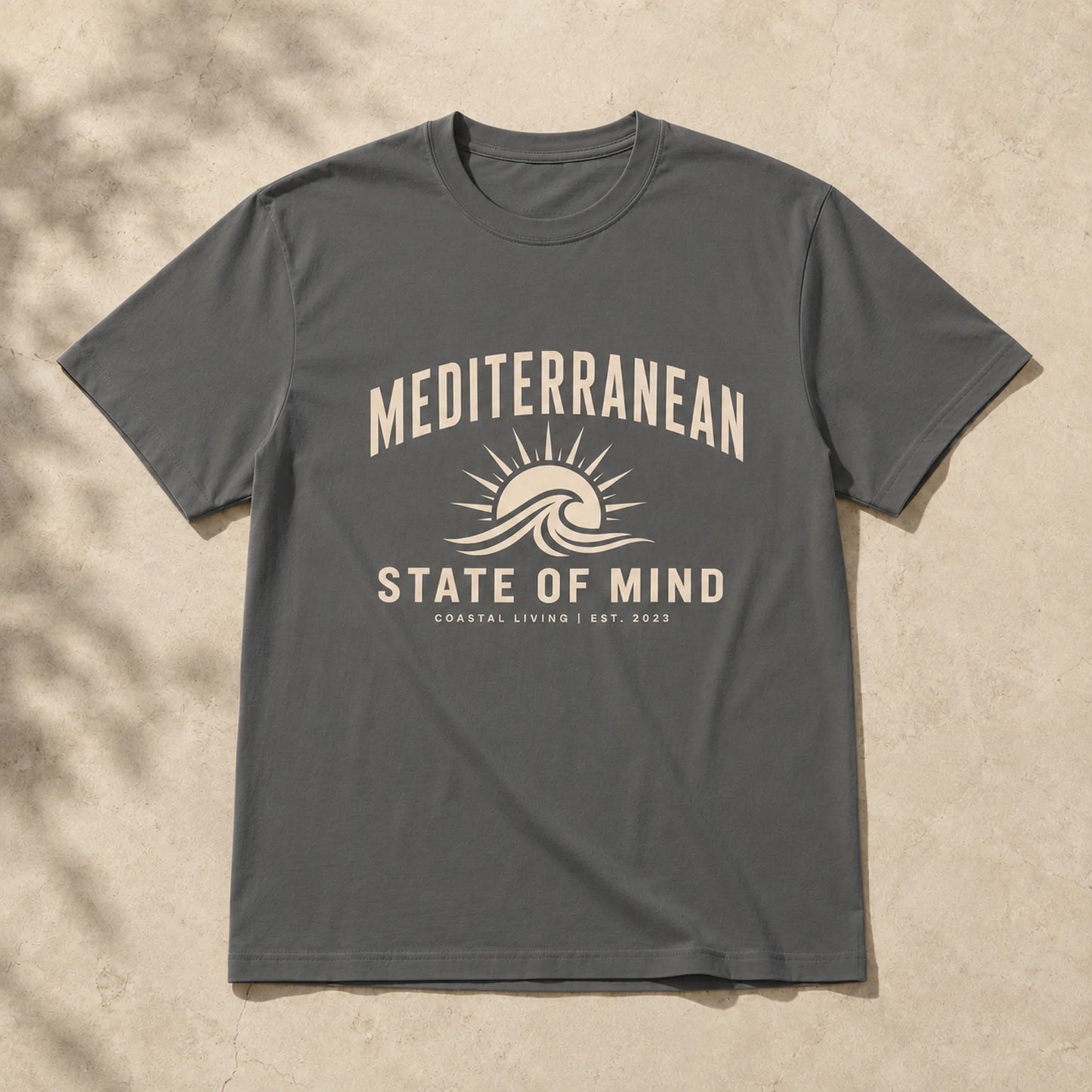Gray t-shirt with 'Mediterranean State of Mind' design on a beige background
