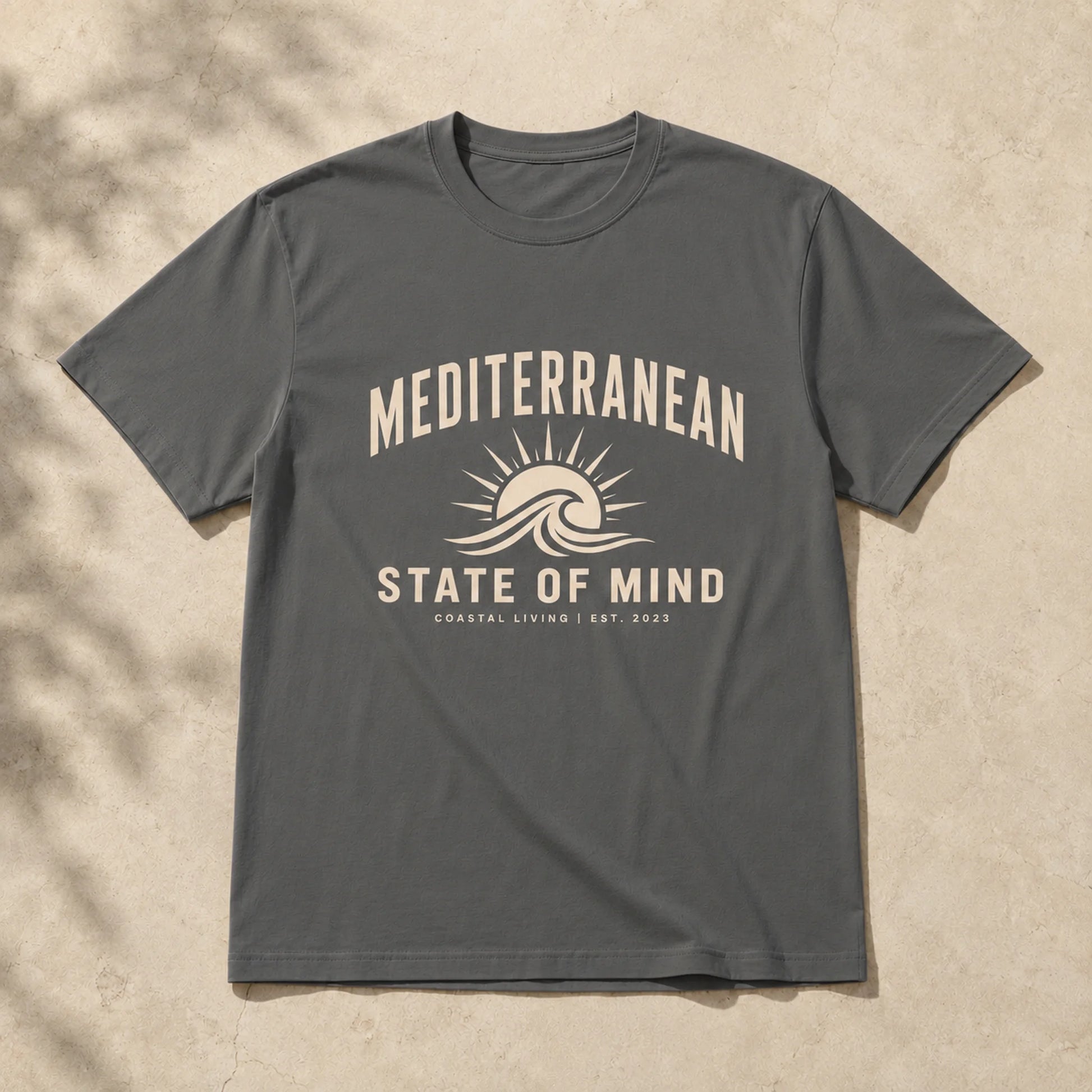 Gray t-shirt with 'Mediterranean State of Mind' design on a beige background