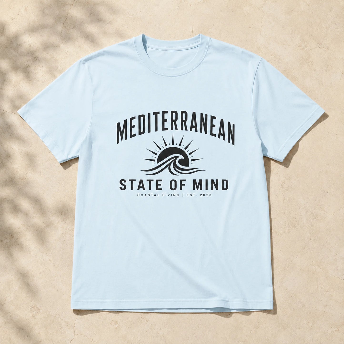 Light blue t-shirt with 'Mediterranean State of Mind' design on a beige background