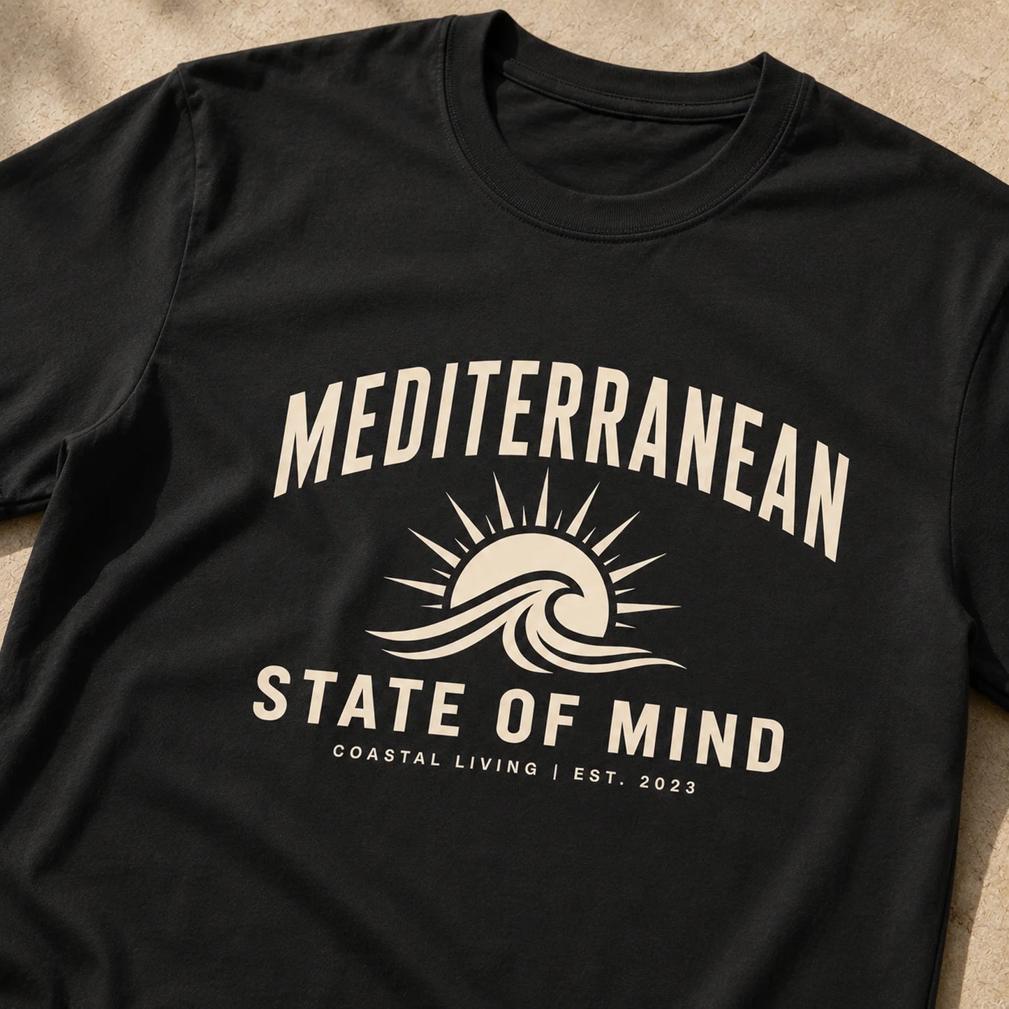 Black t-shirt with 'Mediterranean State of Mind' design on a beige surface