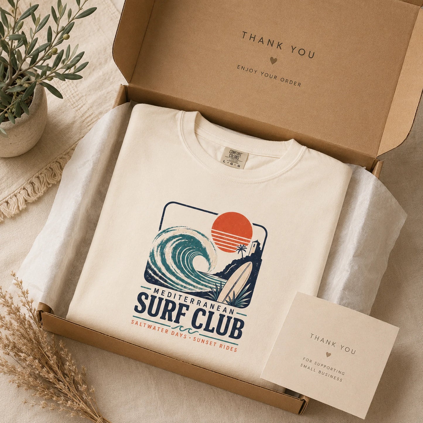 White sweatshirt with 'Mediterranean Surf Club' design in a cardboard box with a 'Thank You' card.