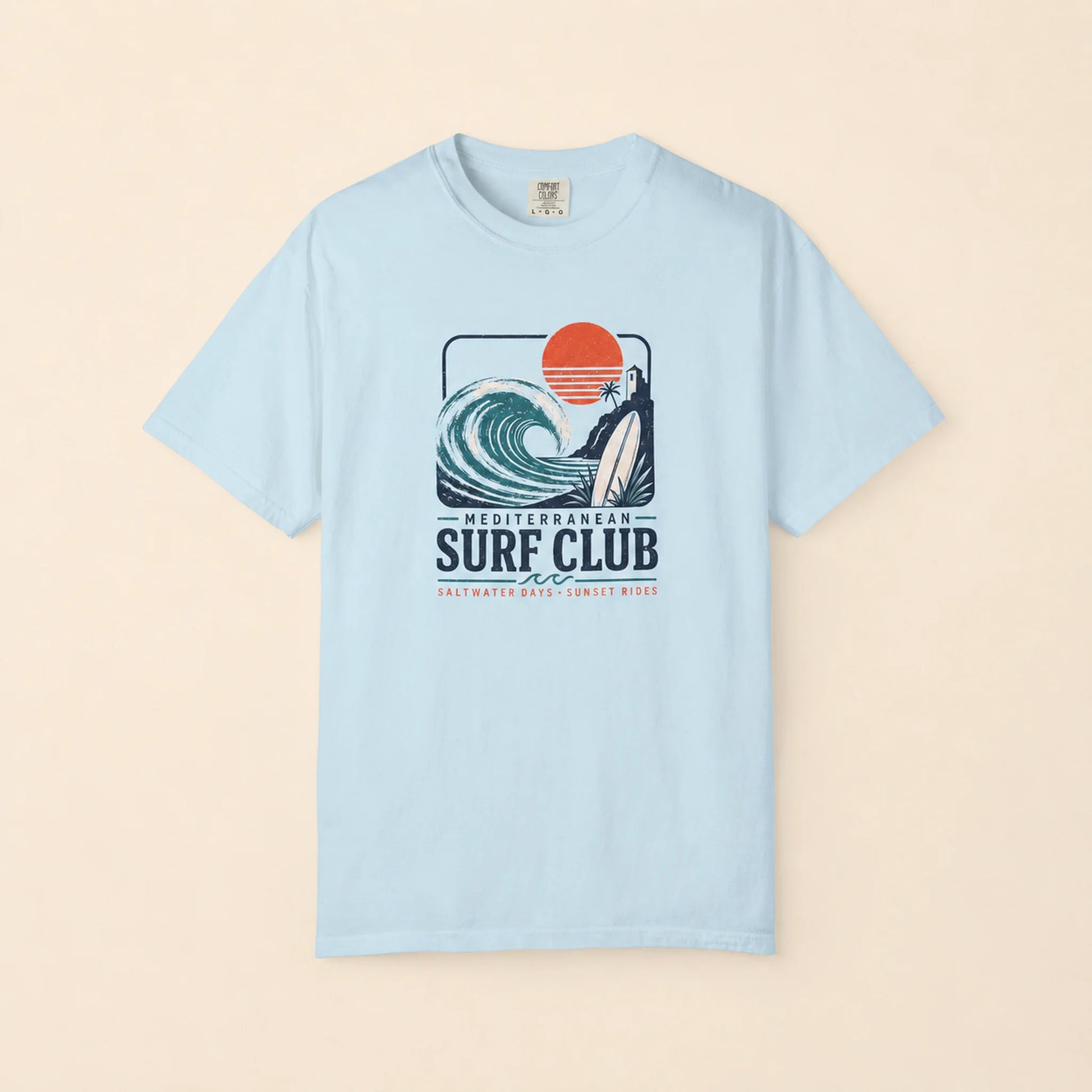 Light blue t-shirt with a surf club graphic on a beige background