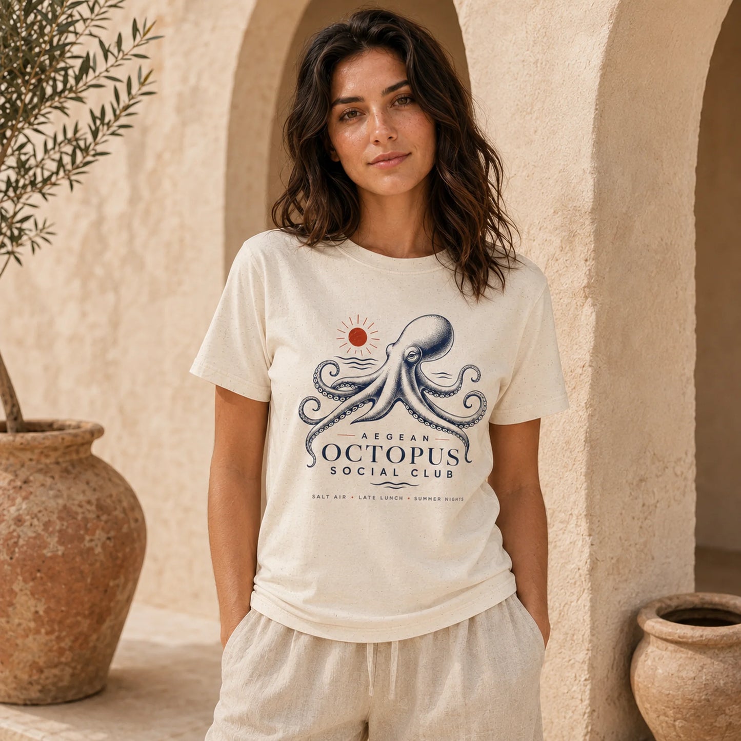 Woman wearing a white t-shirt with an octopus design in a warm, outdoor setting.