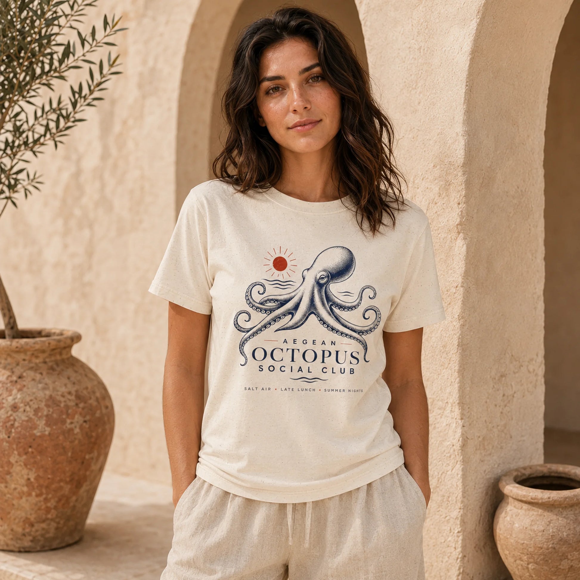 Woman wearing a white t-shirt with an octopus design in a warm, outdoor setting.