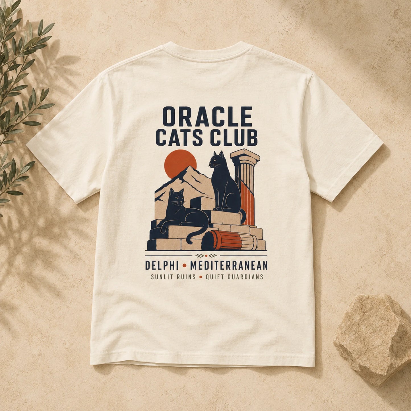T-shirt with 'Oracle Cats Club' design featuring a cat and ancient temple elements on a beige background.