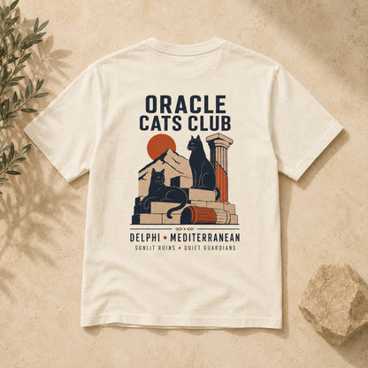 T-shirt with 'Oracle Cats Club' design featuring a cat and ancient temple elements on a beige background.