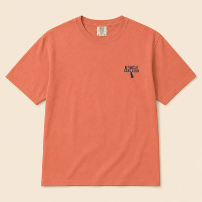Coral t-shirt with 'Oracle Cats Club' logo on a beige background