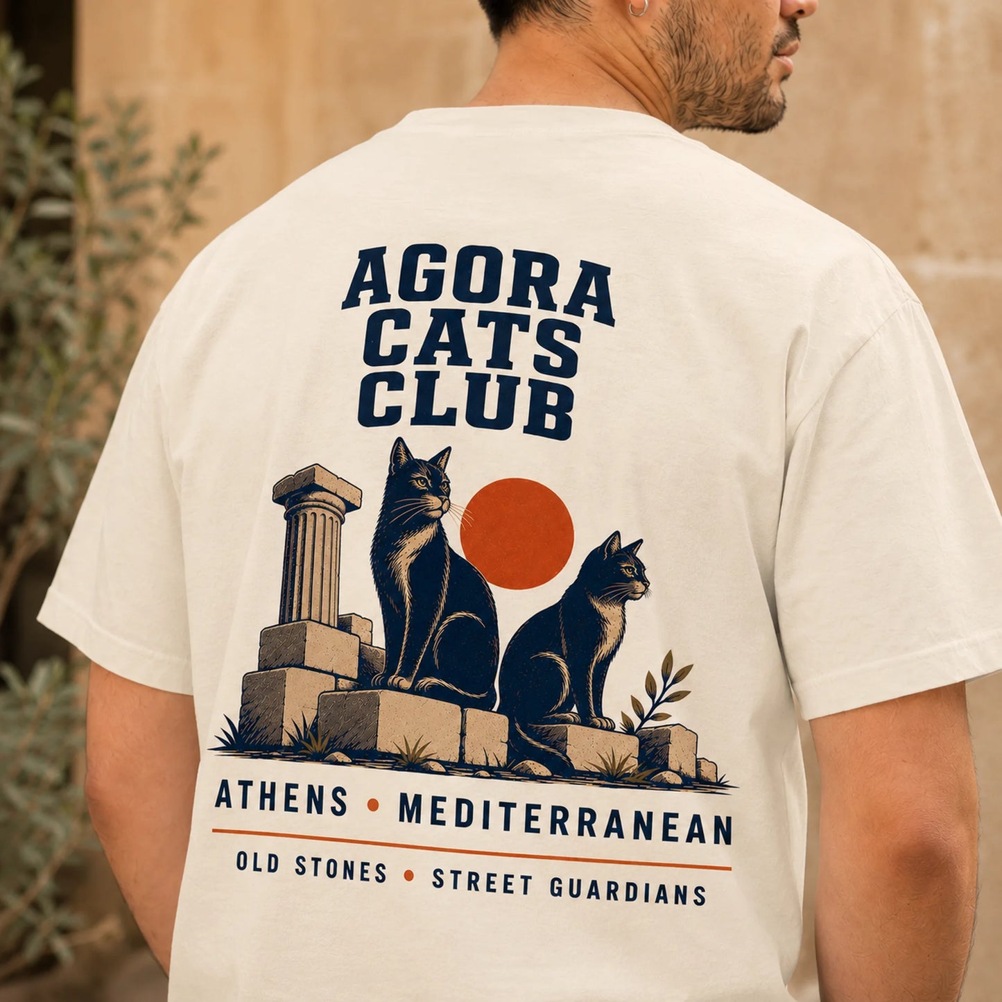 TP HERO: Person wearing a t-shirt with 'Agora Cats Club' design featuring cats and architectural elements.