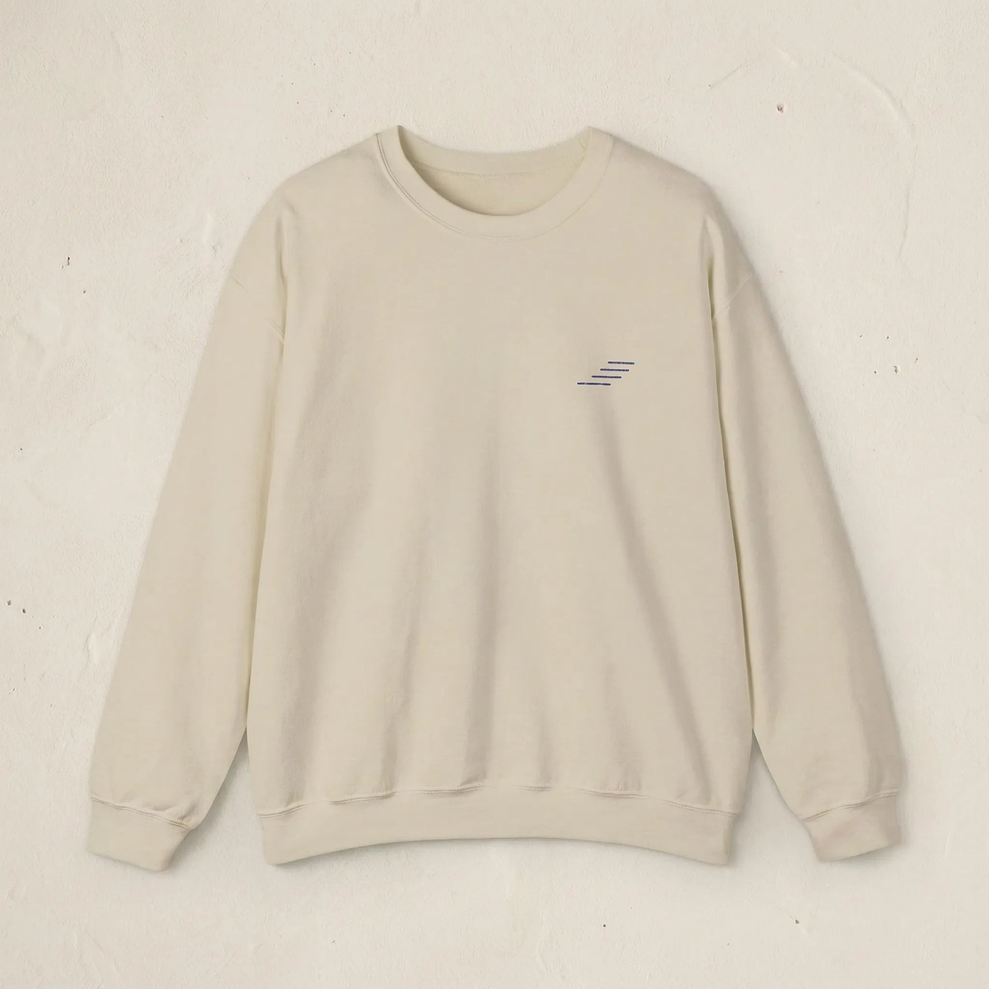 Beige sweatshirt with a small logo on a light beige background