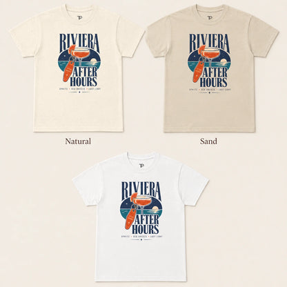 Three short-sleeve graphic T-shirts shown on a light beige background, labeled Natural, Sand, and White. Each shirt features a large front print with the words “RIVIERA AFTER HOURS,” a cocktail illustration, and small text below.