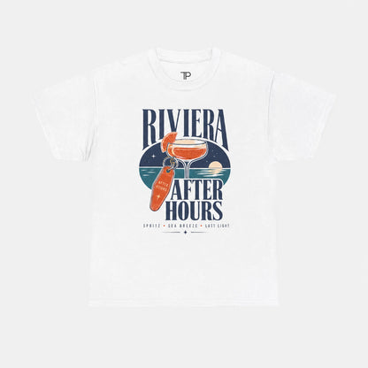 A white short-sleeve crewneck t-shirt featuring a retro-style graphic print on the front. The graphic displays the text 'RIVIERA AFTER HOURS' in navy blue, surrounding an illustration of an orange cocktail in a glass and an orange bottle, with 'SPRITZ - DAN MEEKER - L.