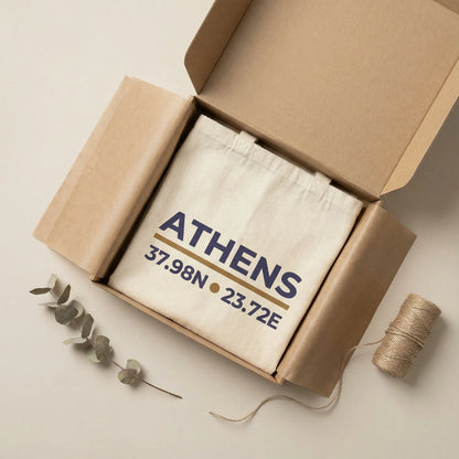 Athens coordinates tote bag packaging presentation on a light neutral surface.