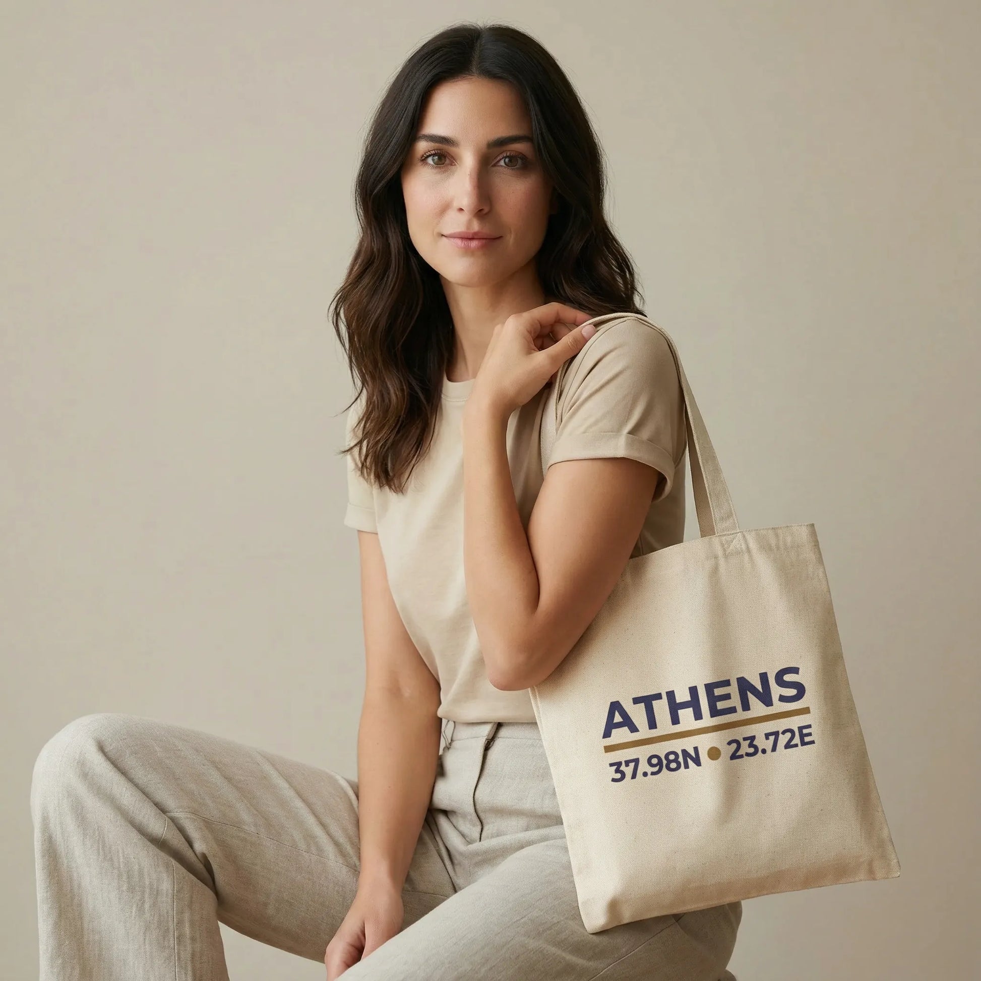 TP:HERO Model holding natural cotton canvas tote with Athens coordinates print, front view.