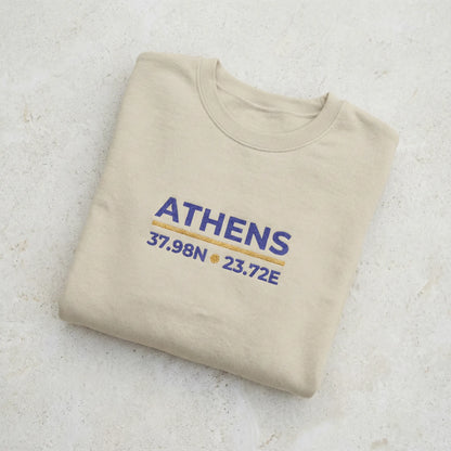 Folded sand crewneck sweatshirt showing fabric texture and embroidery detail