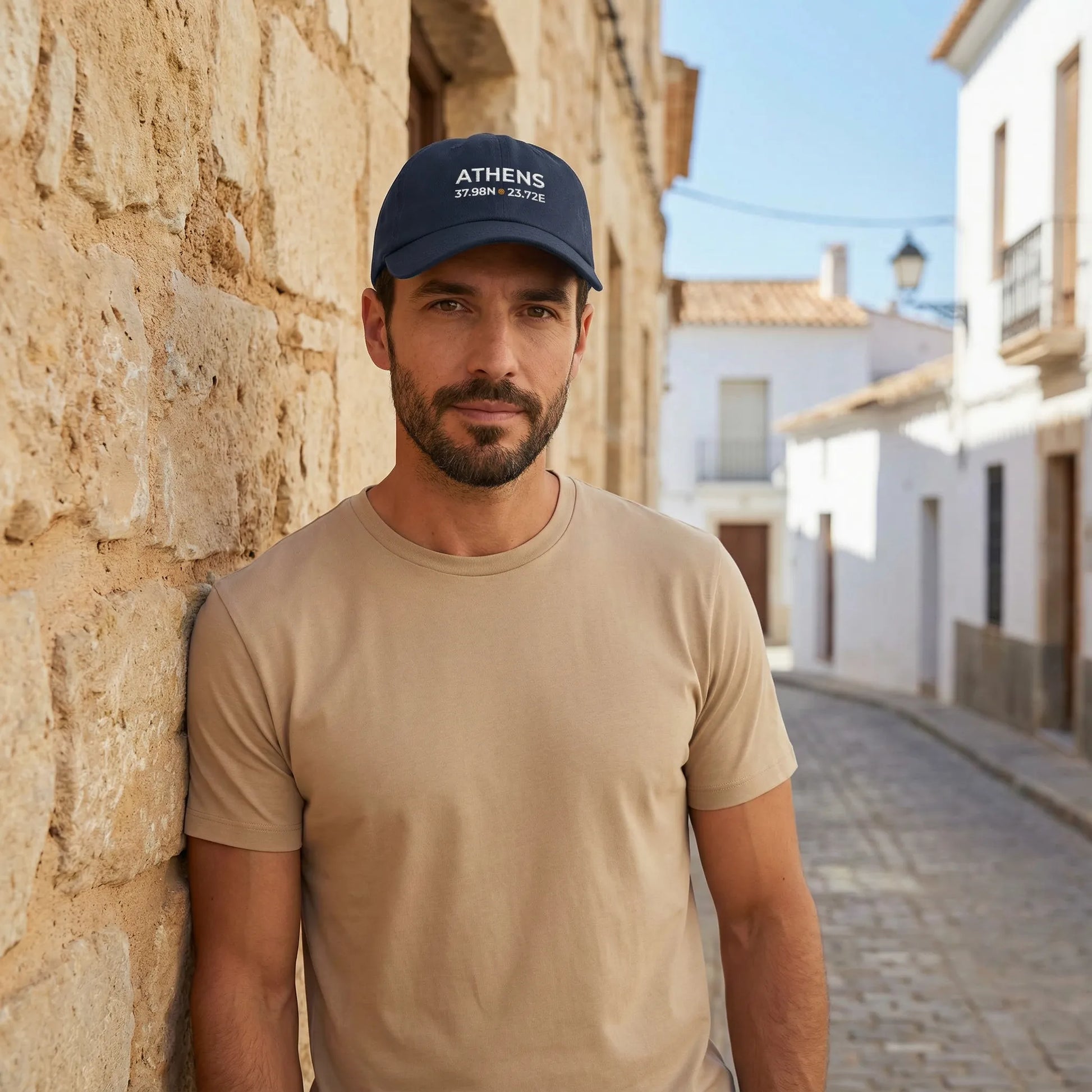 Model wearing Athens coordinates dad cap in Mediterranean outdoor setting.
