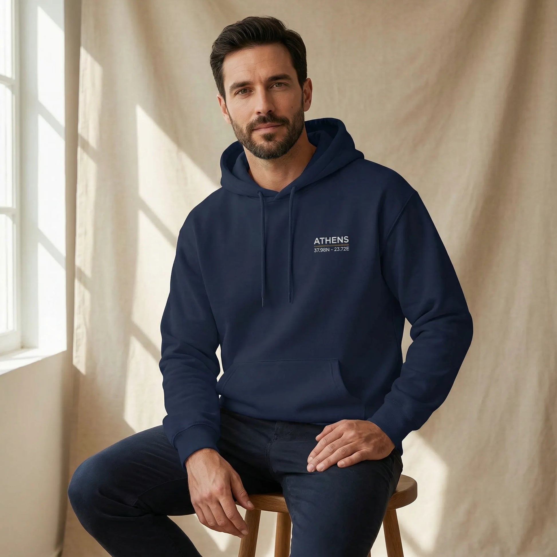 Relaxed studio lifestyle image of navy Athens coordinates embroidered hoodie