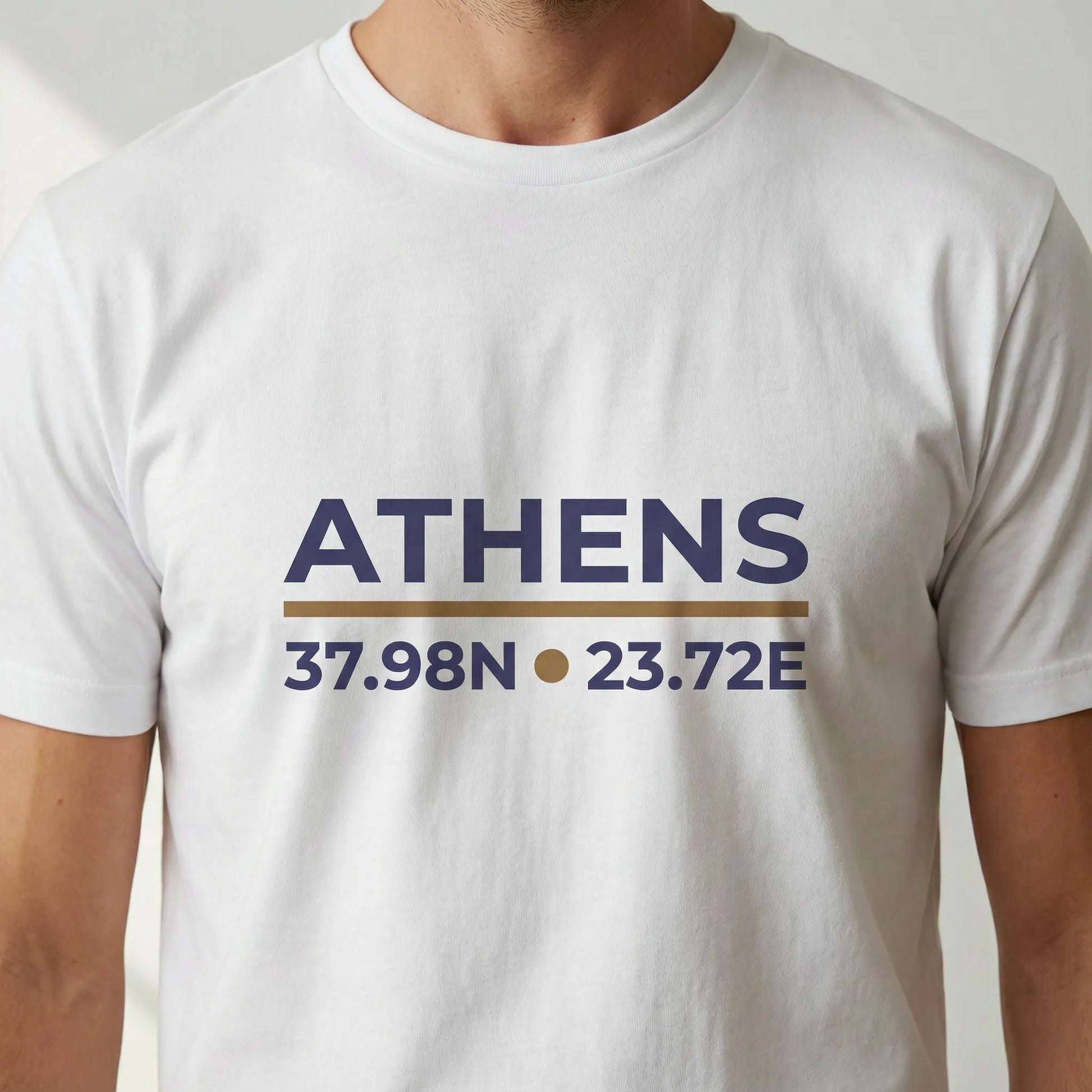 Close-up of ATHENS coordinates print on white t-shirt showing 37.98N and 23.72E.
