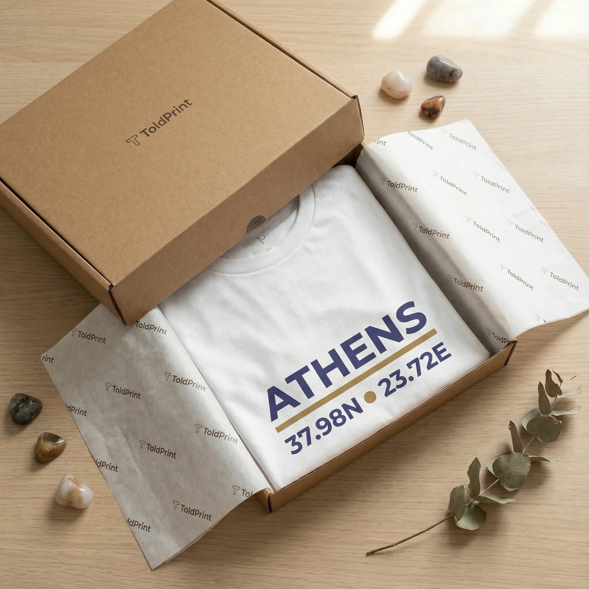 Athens coordinates t-shirt packaging presentation with folded tee in minimal kraft box.