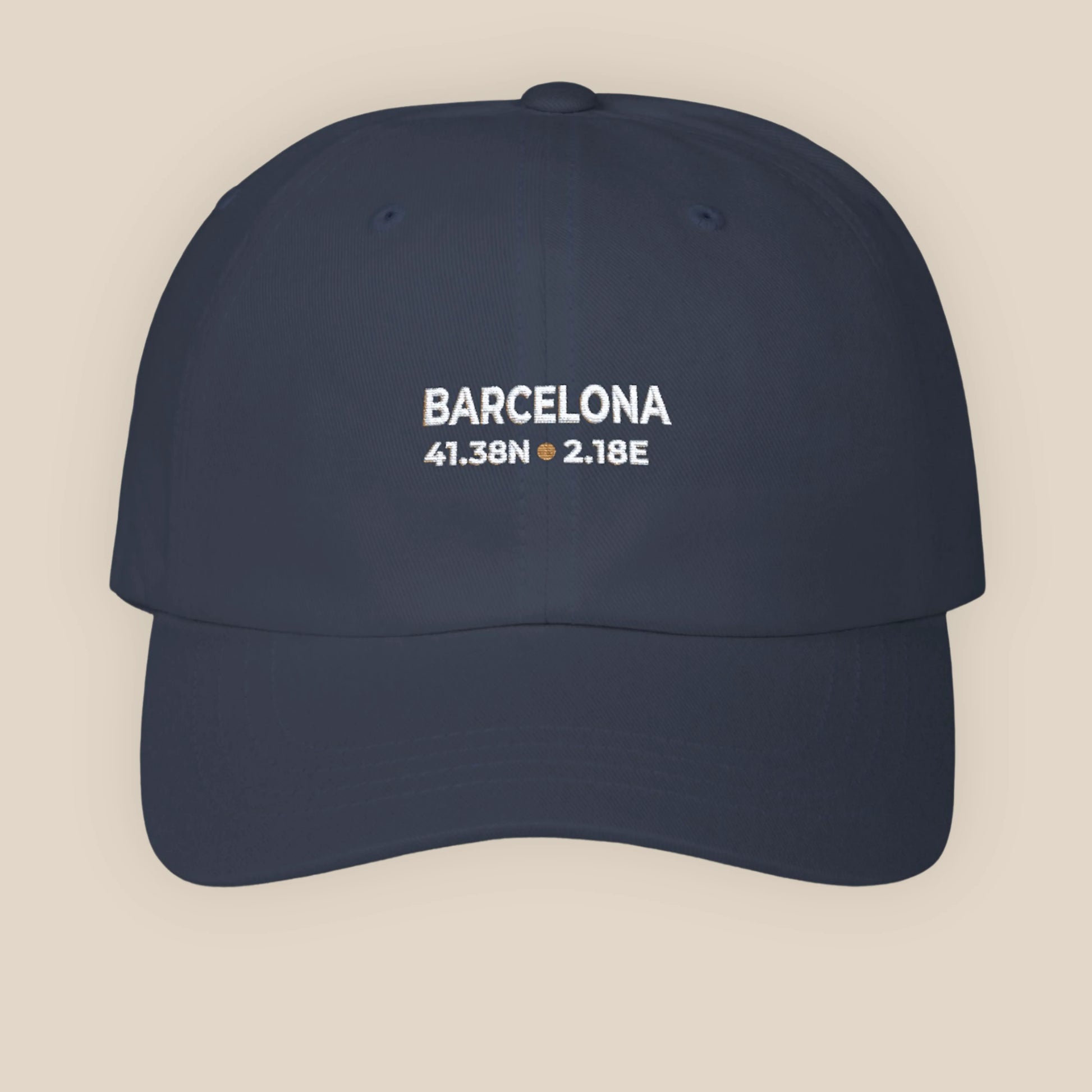 Navy blue cap with 'Barcelona' and coordinates on a beige background
