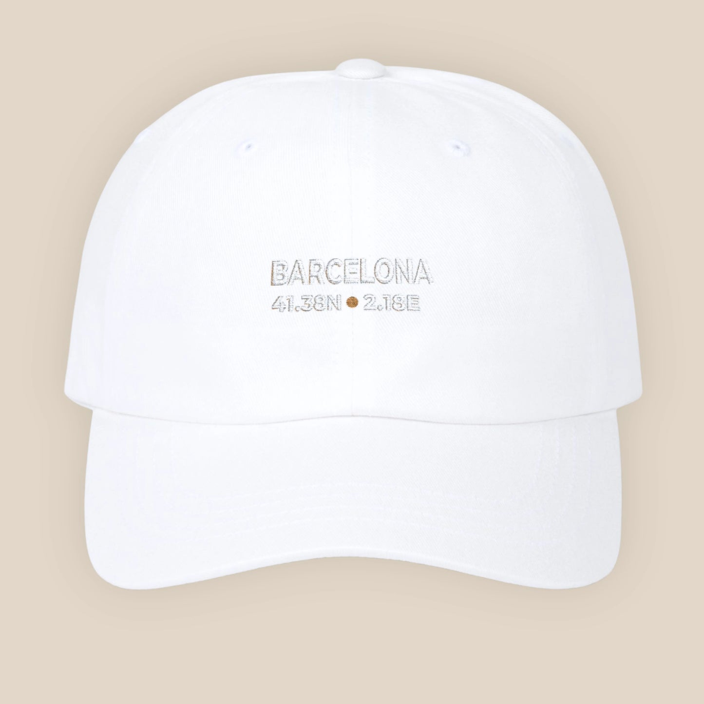 White cap with 'Barcelona, Spain' text on a beige background