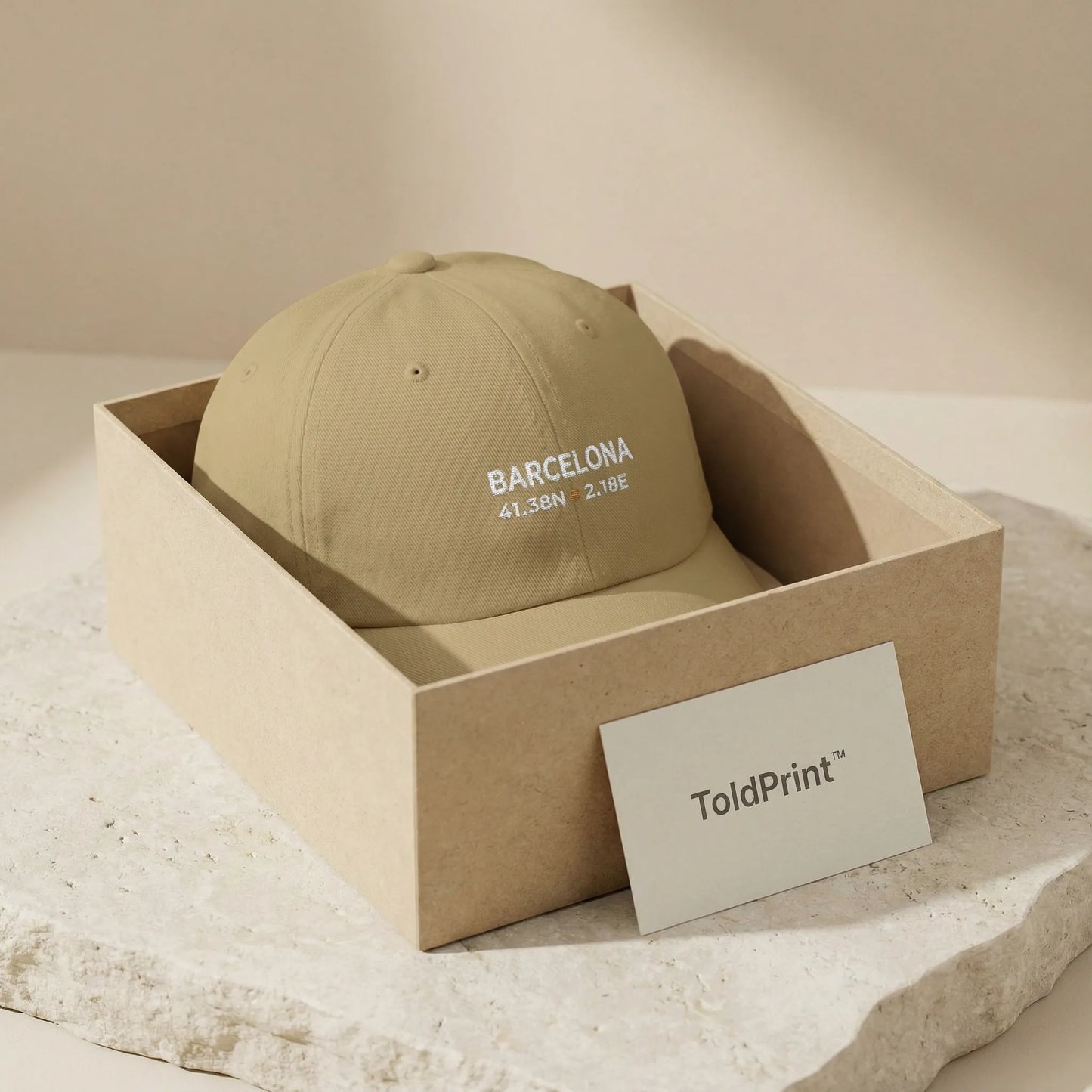 Beige cap with 'Barcelona' text in a cardboard box, featuring ToldPrint branding.