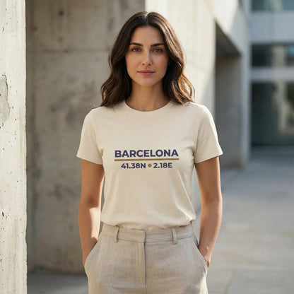 Woman wearing a t-shirt with 'Barcelona' and coordinates, standing against a concrete wall.
