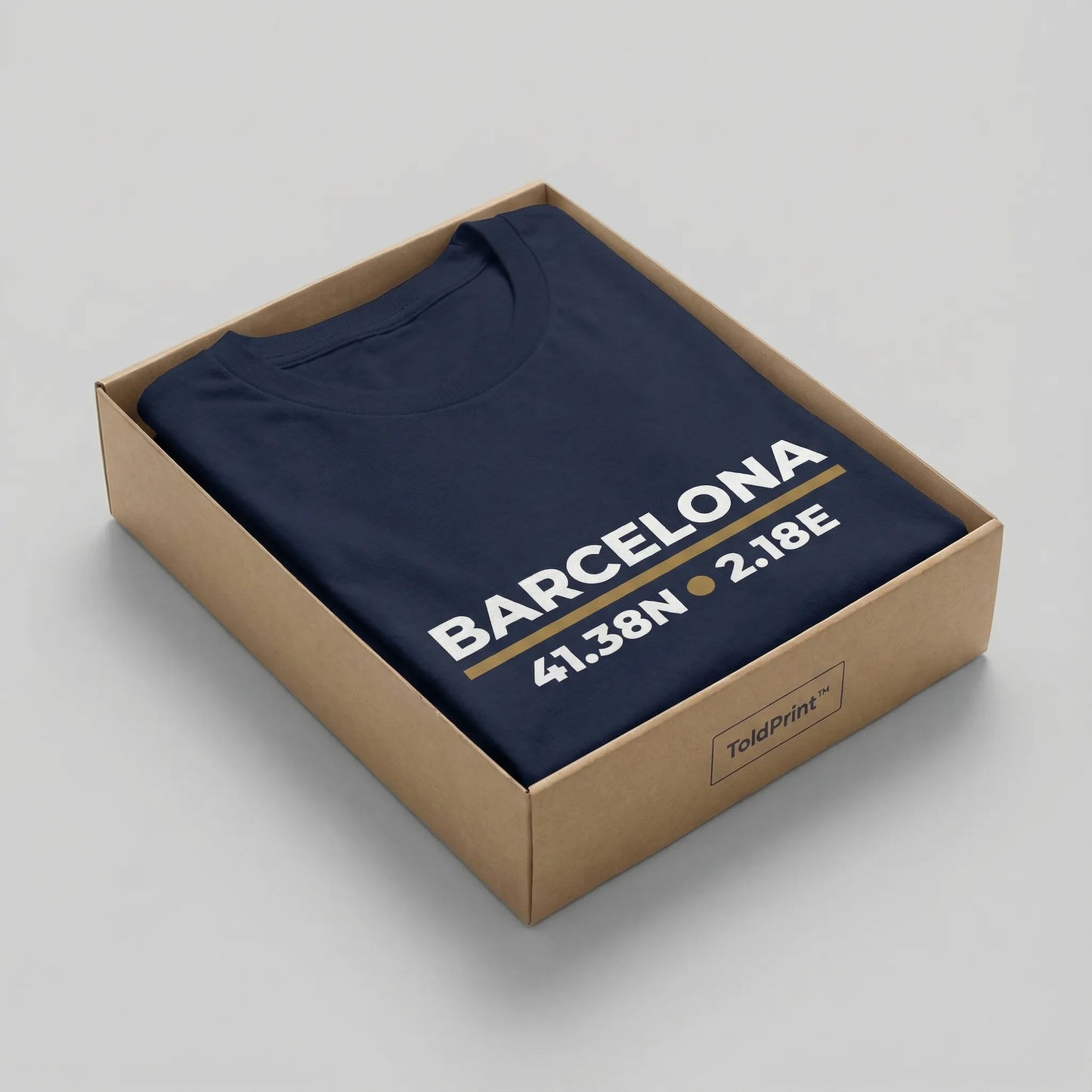 Navy blue t-shirt with 'Barcelona' and coordinates printed on it, inside a cardboard box.
