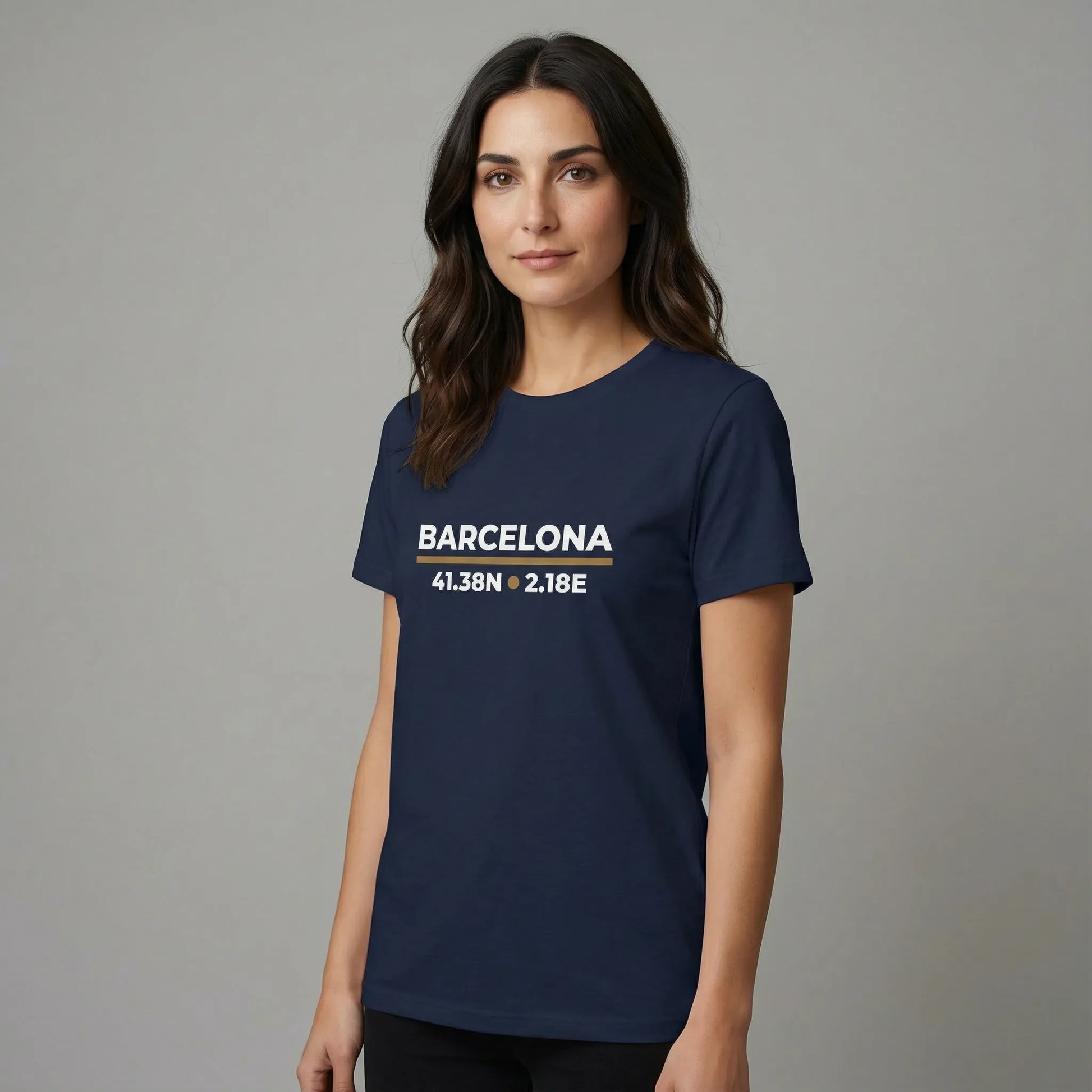Woman wearing a navy blue t-shirt with 'Barcelona' and coordinates printed on it against a gray background