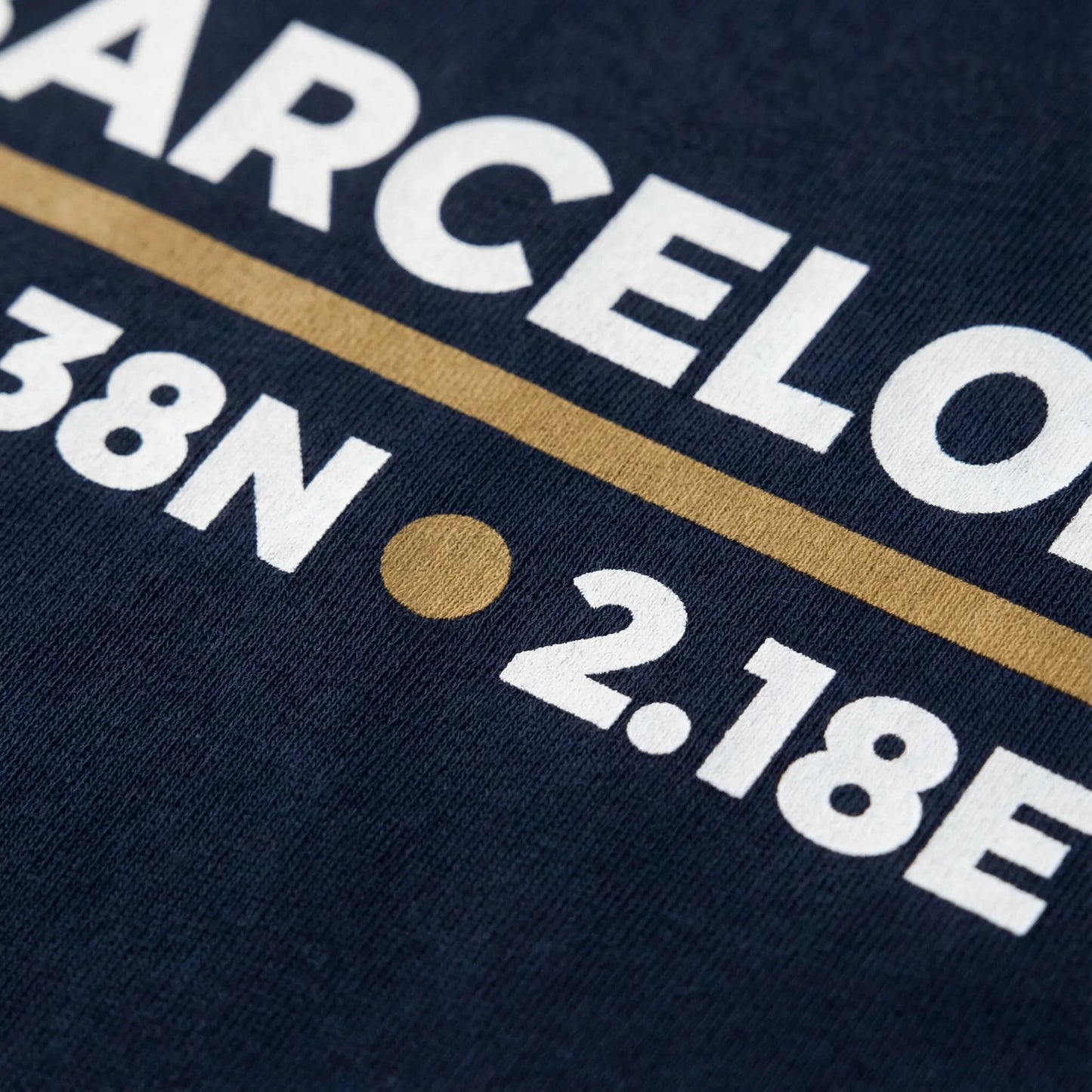 Navy blue shirt with white text and a gold line on a dark background