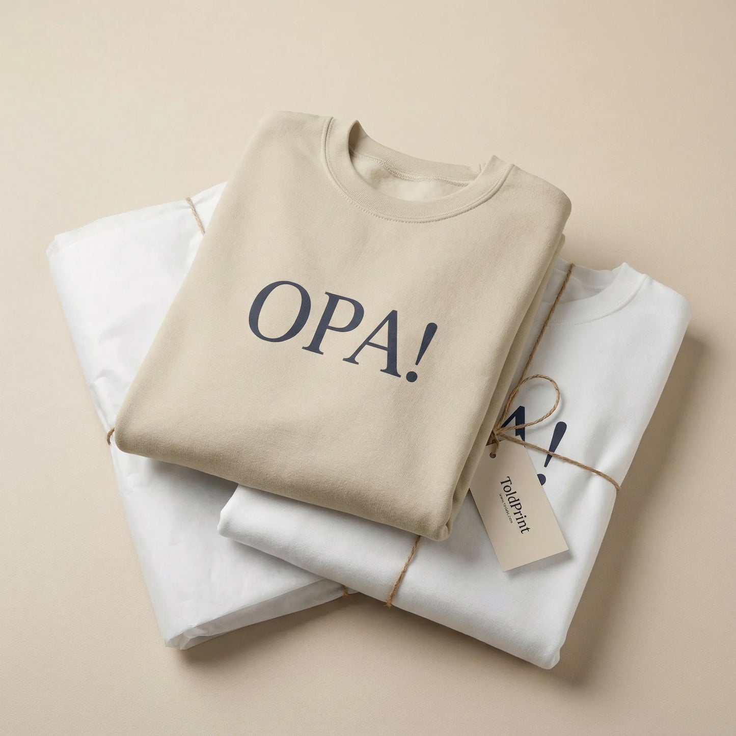Folded sand Celebratory OPA crewneck sweatshirt with OPA print visible and minimal ToldPrint packaging