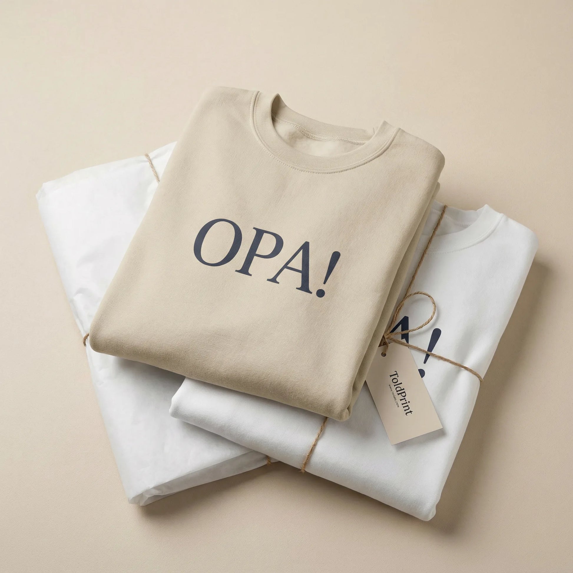 Folded sand Celebratory OPA crewneck sweatshirt with OPA print visible and minimal ToldPrint packaging