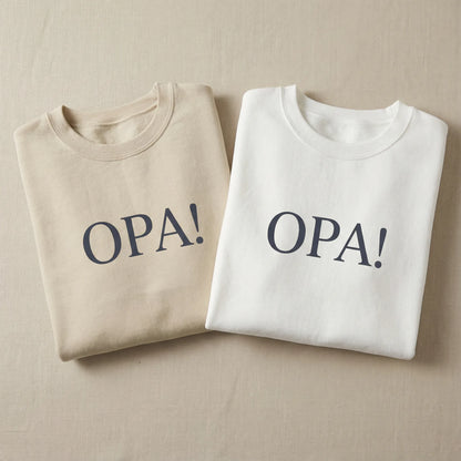 White and sand Celebratory OPA crewneck sweatshirts laid flat with identical OPA front print