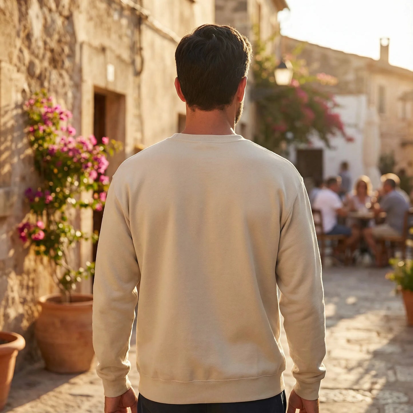 Unisex model wearing Celebratory OPA crewneck sweatshirt on an evening Mediterranean street walk