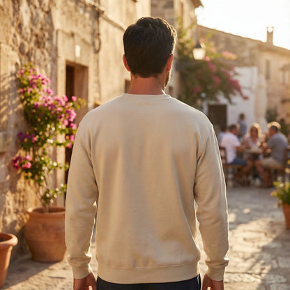 Unisex model wearing Celebratory OPA crewneck sweatshirt on an evening Mediterranean street walk