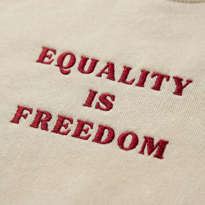 Close-up of deep red Equality Is Freedom embroidery on Sand fleece