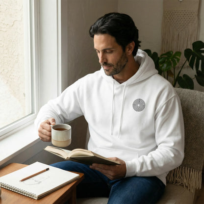 Indoor calm scene showing front chest glyph and relaxed unisex fit of Labyrinth Hoodie