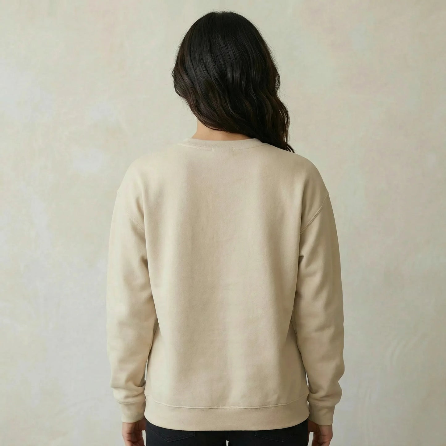 Person wearing a beige sweatshirt against a plain background